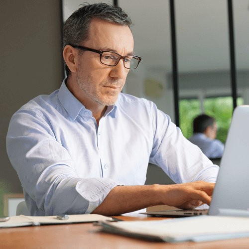a man is sat working on his laptop
